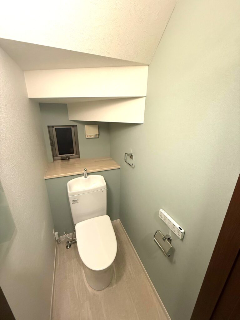 クロスは2カラーで分けました。淡いグリーンとホワイトの組み合わせに加え、クッションフロアも淡いベージュ系なので清潔感あふれるトイレになりました。